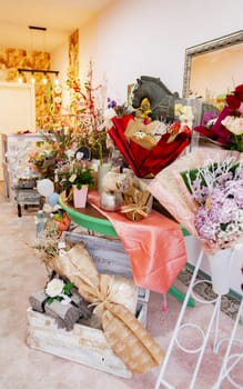 A colorful flower shop showcases an array of exquisite floral arrangements in various shapes and sizes. Soft lighting and rustic decor create a warm and inviting atmosphere.