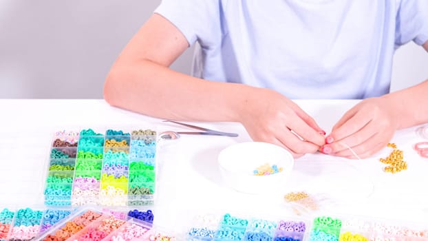 Delicate fingers of a young girl navigate through a treasure trove of bright, multicolored beads, each compartment revealing a new hue to choose from.