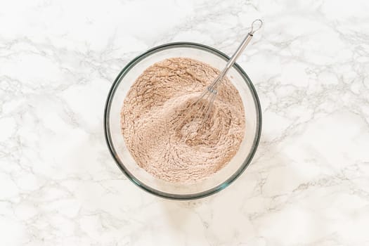 Top view of a bowl containing flour and spices for Chocolate Ginger Sugar Cookie Dough, highlighting key ingredients like ginger and cocoa powder.