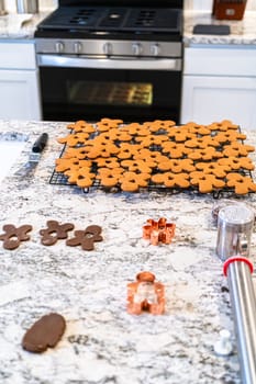 In a contemporary white kitchen, gingerbread cookie dough is skillfully rolled out, setting the stage for a delightful holiday treat.