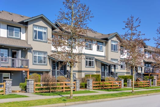 Street of residential townhouses on bright spring day in British Columbia, Canada.