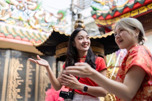 Two friends share laughter and stories during Chinese New Year festivities embodying joy and cultural connection.