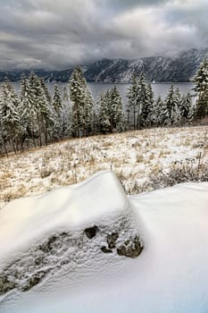A look down at snow covered trees and mountains in the background by Pend Oreille Lake in Idaho.