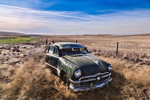 An old abandoned antique car sitting in a field in eastern Washington.