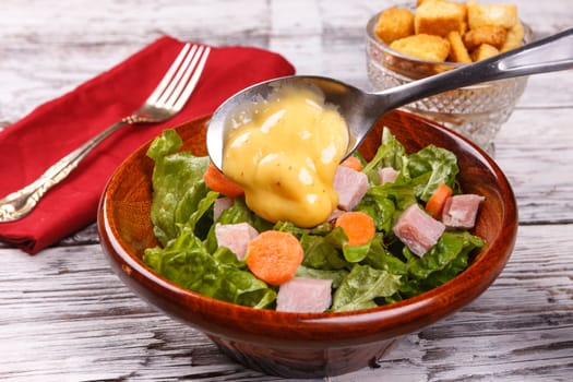 Close up of a delicious salad with honey mustard dressing.