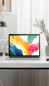 A vibrant abstract art sticker adorns a glossy white laptop set on a modern workspace. the scene features clean lines, natural lighting, and lush greenery, creating an inspiring environment for creativity and productivity.