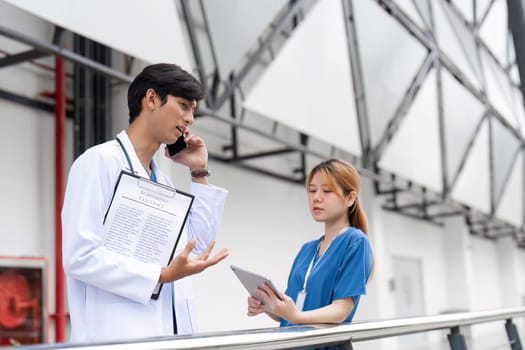 A doctor and nurse engage in a critical discussion about patient care emphasizing teamwork in a hospital environment.