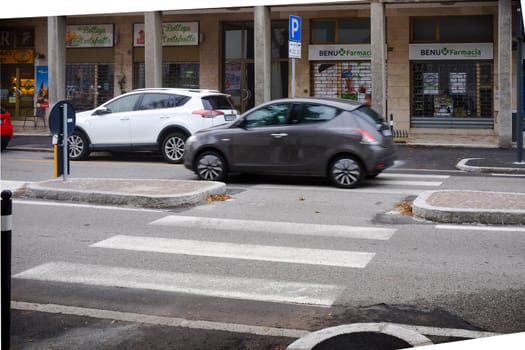Cremona, Itally - October 6th 2024 Gray lancia ypsilon 1.2 8v 69 hp 2011 driving through pedestrian crossing in urban street