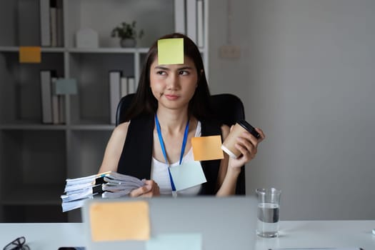 Office worker surrounded by documents, multitasking in a modern office environment, showcasing productivity and organization.
