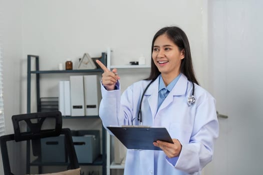 Confident female doctor smiling in a modern office, holding a clipboard and stethoscope, representing professionalism in healthcare.