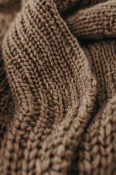 Luxuriate in the warmth and texture of a mocha mousse knitted scarf, carefully folded. the intricate patterns highlight the craftsmanship, complemented by an attached handmade label, making it perfect for fashion lovers and diy enthusiasts.