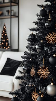 A stylish black Christmas tree adorned with gold ornaments in a cozy setting.