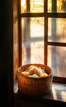 A woven basket filled with food sits on a windowsill, illuminated by light.