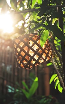 A woven lantern hanging amidst lush greenery, illuminated by sunlight.