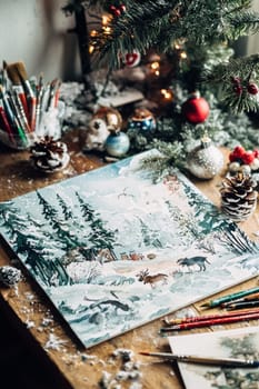 A watercolor advent calendar featuring snowy landscapes and winter animals, surrounded by art supplies on a wooden table. perfect for festive home decor, creativity and holiday spirit with a cozy, artistic touch.