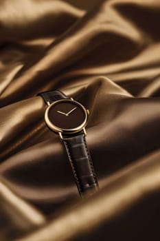 Stylish minimalist wristwatch with a mocha mousse face and gold accents, elegantly displayed on textured fabric. ideal for high-end accessory marketing, emphasizing exquisite craftsmanship and luxurious design suitable for premium campaigns.