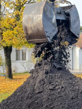 France, Gironde, December 2024, Delivery of topsoil by truck crane to the garden of a residential house. High quality photo