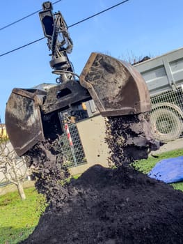 France, Gironde, December 2024, Delivery of topsoil by truck crane to the garden of a residential house. High quality photo
