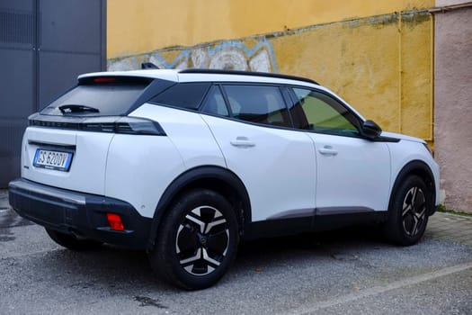 Cremona, Itally - October 6th 2024 Stylish white peugeot 2008 suv with 1.2 puretech 130 hp engine, parked by a yellow wall, highlighting its modern design
