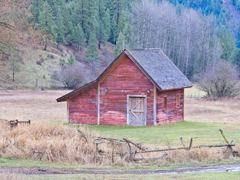 A small red barn stands in a field late in the year in north Idaho.