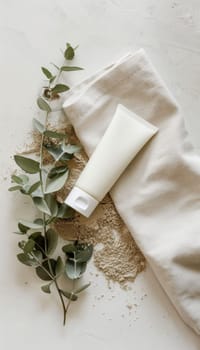 Mocha mousse hand cream stands elegantly next to a beige towel and eucalyptus sprig on a textured stone surface, evoking a serene spa ambiance. ideal for promoting skincare products or soothing bath essentials in wellness media.