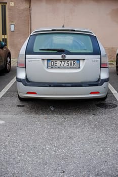 Cremona, Itally - October 6th 2024 Rear view of a silver saab 9-3 sportcombi 1.9 tid parked in a designated parking spot on an asphalt surface, offering a glimpse of urban life