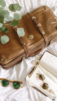 Stylish flat lay arrangement featuring mocha luggage, sunglasses, a travel journal, a straw hat, and a cup of mocha mousse on a crisp white linen backdrop. an elegant composition ideal for travel, fashion, or lifestyle design themes.