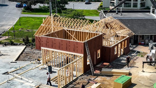 Bird in Hand, Pennsylvania, USA, June 6-2024 - Construction project is progressing with workers actively framing a new building at a commercial location. The structure has wooden frames