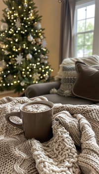 Mocha mousse knit blanket drapes gently over furniture, paired with a steaming mug of hot cocoa. soft, twinkling lights illuminate the decorated christmas tree in the background, creating a warm and inviting holiday atmosphere.