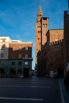 Cremona, Italy - November 27th 2024 The torrazzo bell tower of cremona cathedral rises majestically over piazza comune in the warm morning light