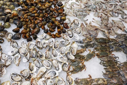 The seafood street market offers a wide range of fresh seafood, including bright orange shrimp, clams and assorted clams on ice