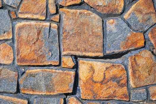 Wall made of old stones. Abstract background and texture for design. The surface of natural masonry. The structure is in the grunge style.