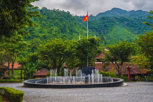 a square with the Vietnamese national flag and fountains in Ba Na Hills on the background of a mountain and a cable car