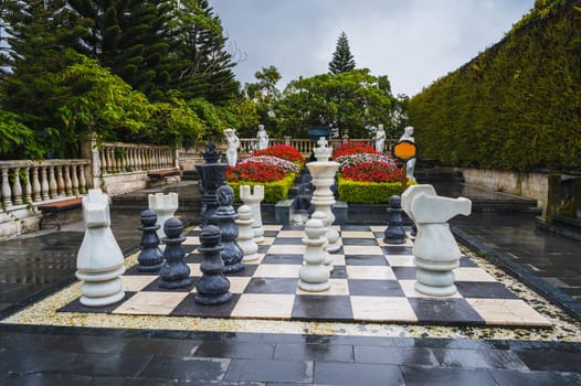 A large chessboard with huge chess pieces on it in the garden at Ba Na Hills.