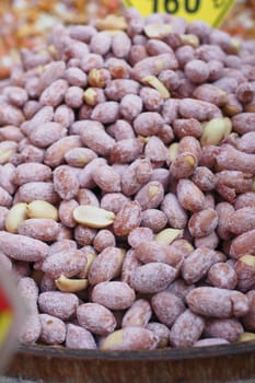 A closeup of sweetcoated roasted peanuts beautifully displayed at a vibrant market