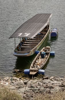 Wooden ferry boat and Traditional hand built small wooden rowboat slowly was resting along in the dam.Transportation by boat, use it as your Wallpaper, Poster and Space for text, Selective focus.