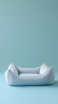 A soft, light blue pet bed on a pastel background.