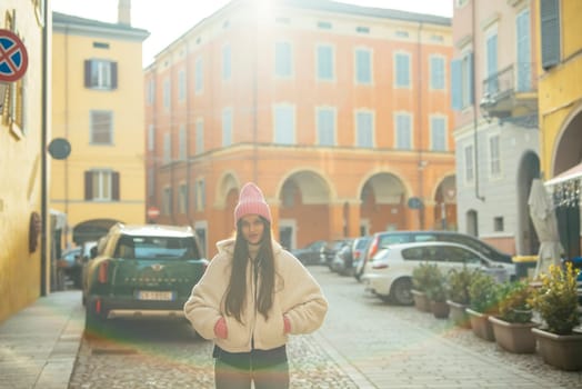 A beautiful scenic view featuring a woman in a cozy outfit, soaking in the sunlight against a vibrant urban backdrop