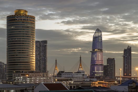 Bangkok, Thailand 15 Dec, 2024 - Evening view after sunset of Skyscraper in the business district in the beautiful sky background. Architectural exterior of Supalai Grand Tower, KingBridge tower and Modern buildings alongside the iconic landmark of Bhumibol Bridge, use it as your Wallpaper, Poster and Space for text, Selective focus.