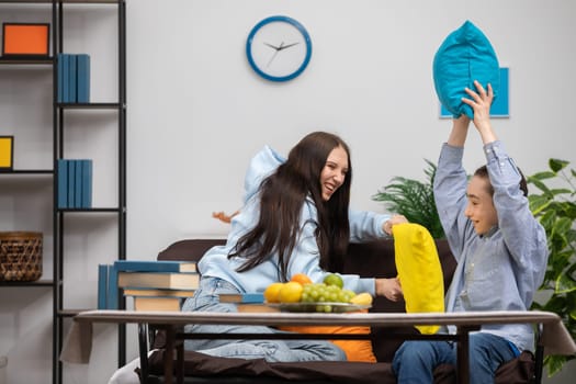 Two close friends engage in an entertaining and lively pillow fight while enjoying a cozy moment indoors