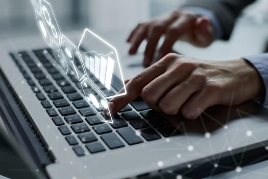 man's hands typing on laptop keyboard in interior