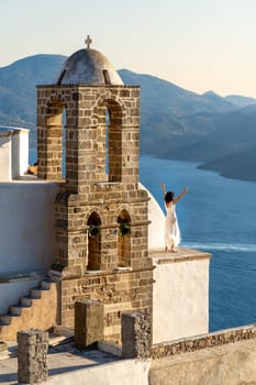 Woman in white dress looking at the sea in church Panagia Thalassitra, Plaka, Milos