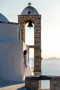 Woman in white dress looking at the sea in church Panagia Thalassitra, Plaka, Milos