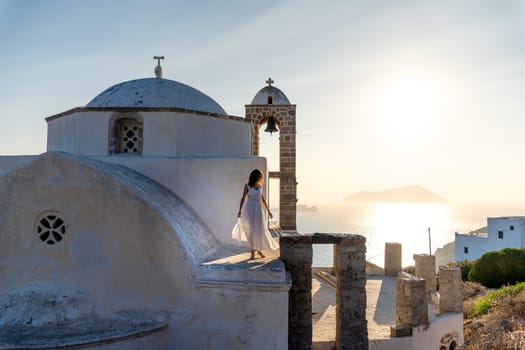Woman in white dress looking at the sea in church Panagia Thalassitra, Plaka, Milos