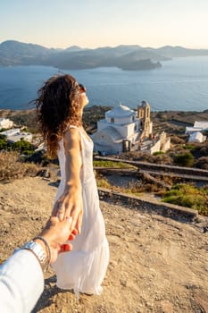 Boyfriend holding his girlfriend's hand in Plaka, Milos