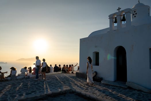 Unknown people watching sunset in Plaka, Milos