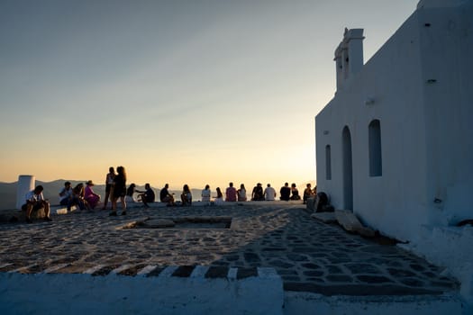 Unknown people watching sunset in Plaka, Milos