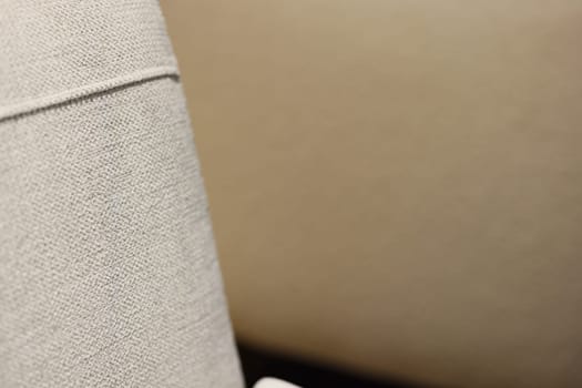 A closeup view of stylish fabric covering contemporary furniture, highlighting its graceful neutral hues