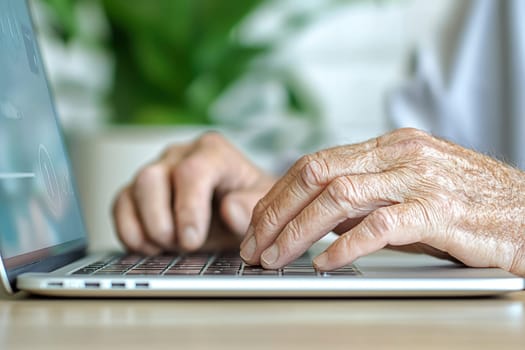 A Close up of elderly man hands carefully typing on laptop keyboard, showcasing focus and concentration