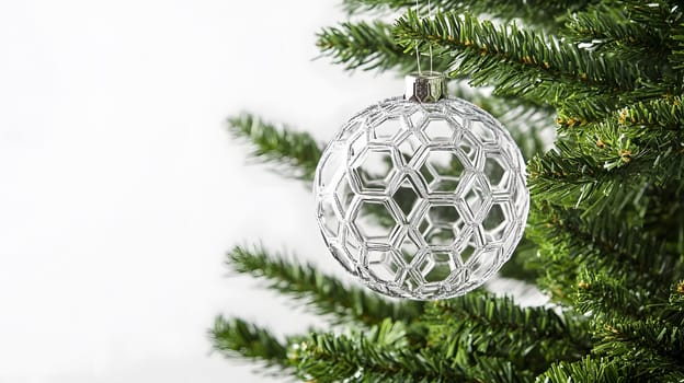 A decorative glass ornament hanging from a Christmas tree branch.